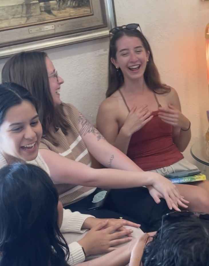 Women laughing together at a Mavens book club meeting