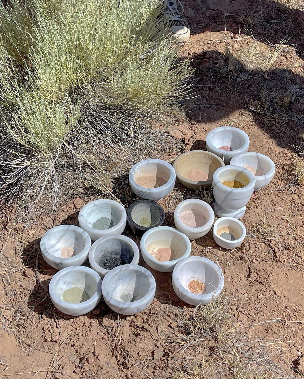 Marble bowls of hand-ground earth pigments in a Florida landscape